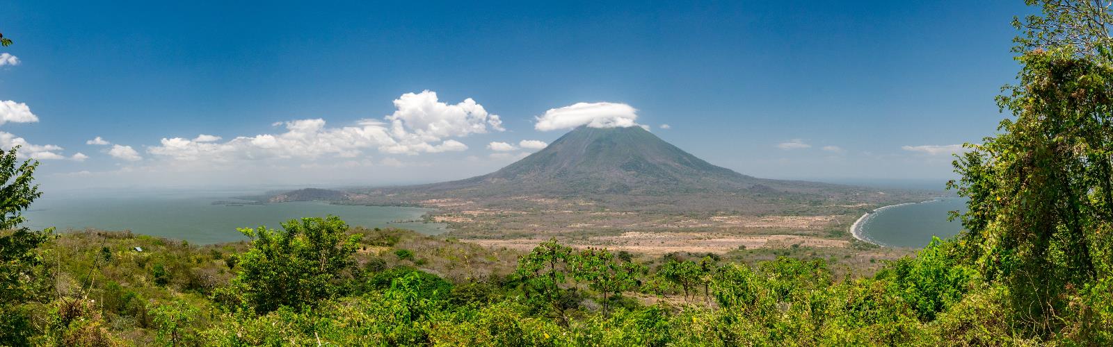 outdoor sky grass mountain cloud nature landscape field hill background stratovolcano shield volcano grassy overlooking extinct volcano volcano hillside highland lush clouds distance land tree plant